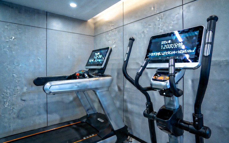 智能跑步机与健身设备，配备触摸屏显示实时心率与运动数据